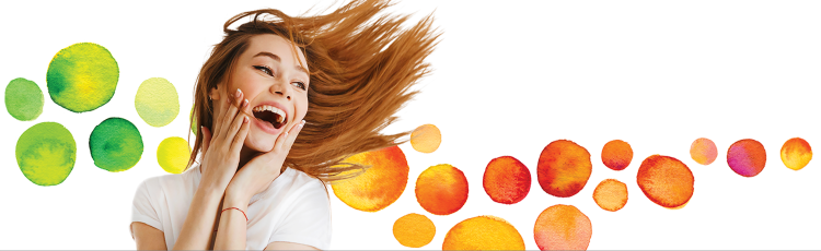 woman jumping and holding up hands to her face while smiling