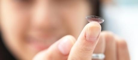 woman holding a contact lens