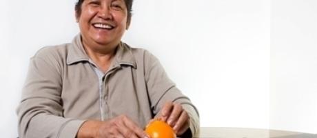 woman smiling and holding an orange