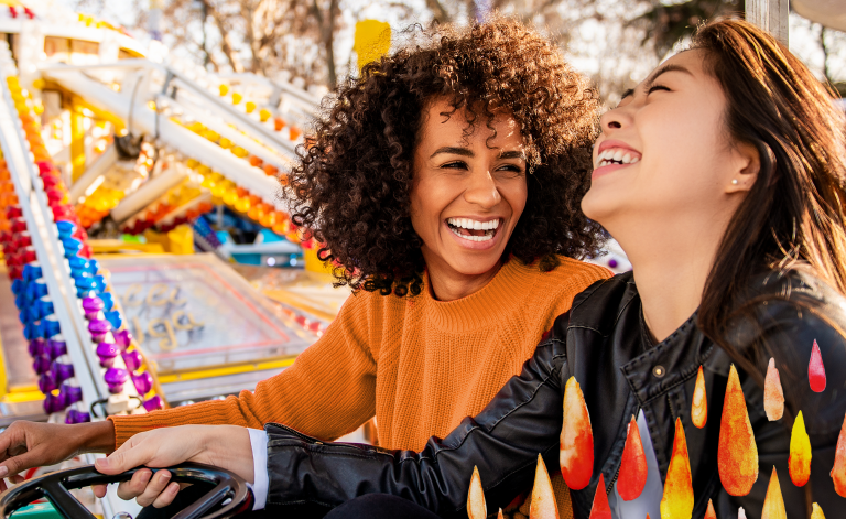 women smiling on a ride at the fair