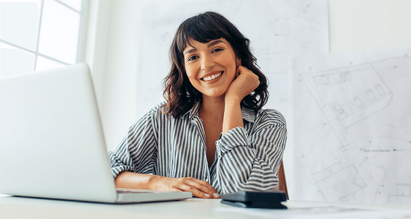 woman smiling and using a laptop